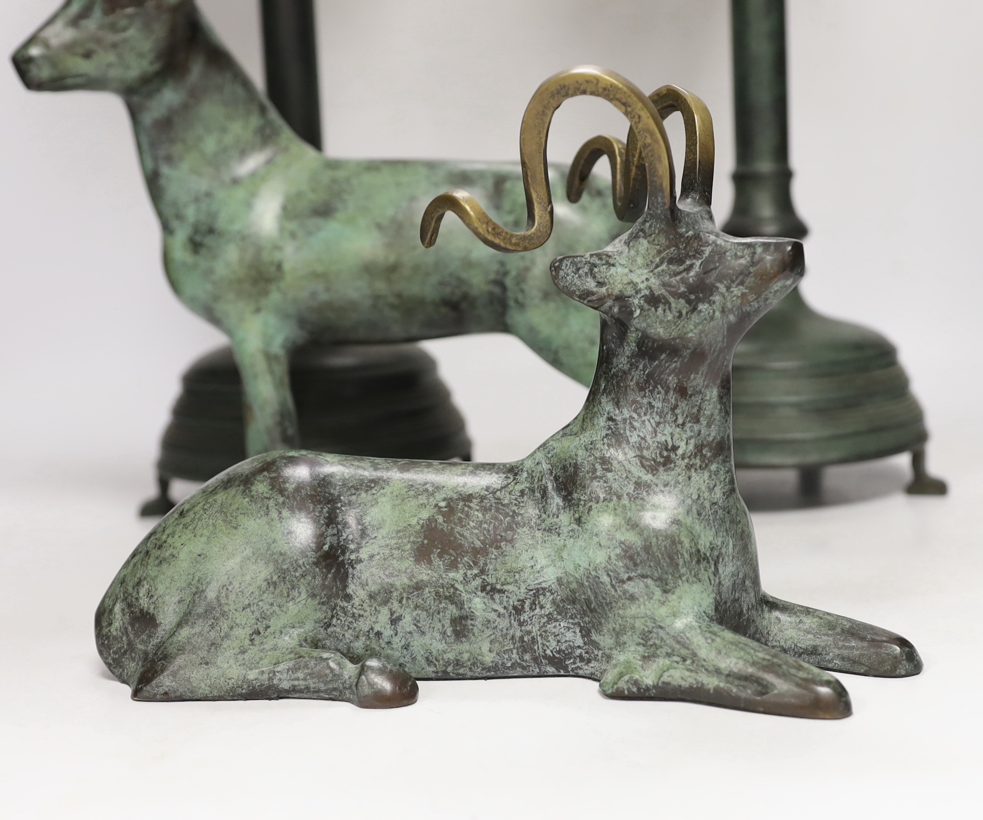 A pair of bronze candlesticks, 45.5cm, and a pair of stags, all with green patina